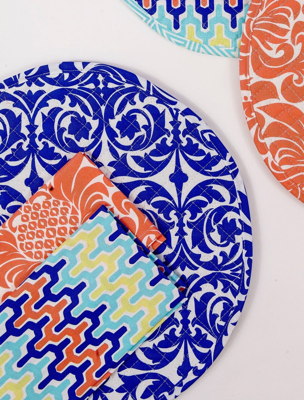 Hen House Linens garden gate santorini blue reversible arabesqu aqua blue printed round quilted cloth placemats